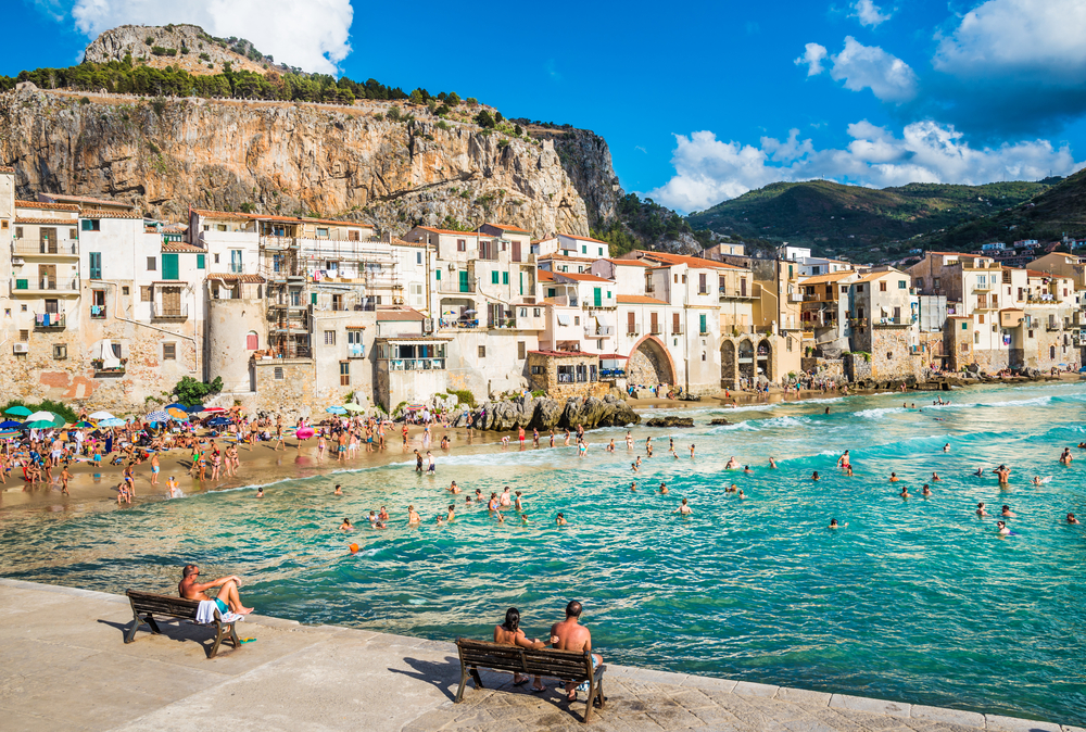 CEFALU, SICILY - AUGUST.12. 2017: People on beautiful beach at the bay in Cefalu, Sicily.Cefalu is very popular touristic old town in Sicily.