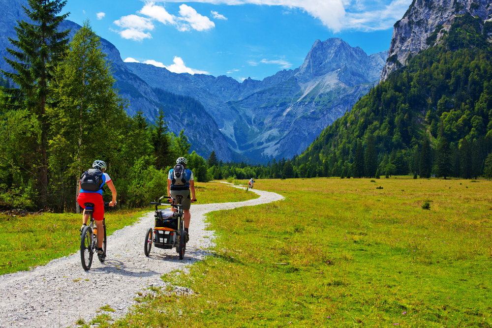 Cyclists on Alps mountains landscape background.
