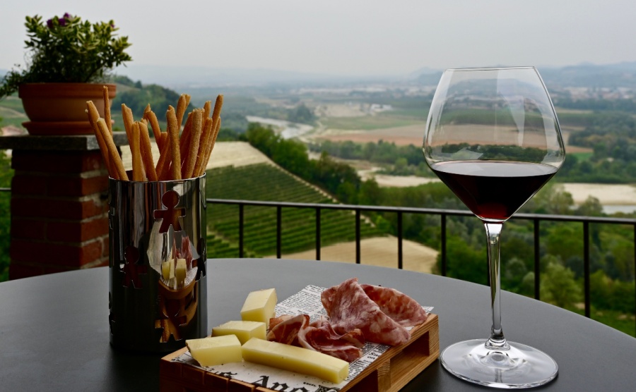 Aperitivo in the Barolo region. Glass of Barolo wine, some local cheese and meats and some breadsticks.